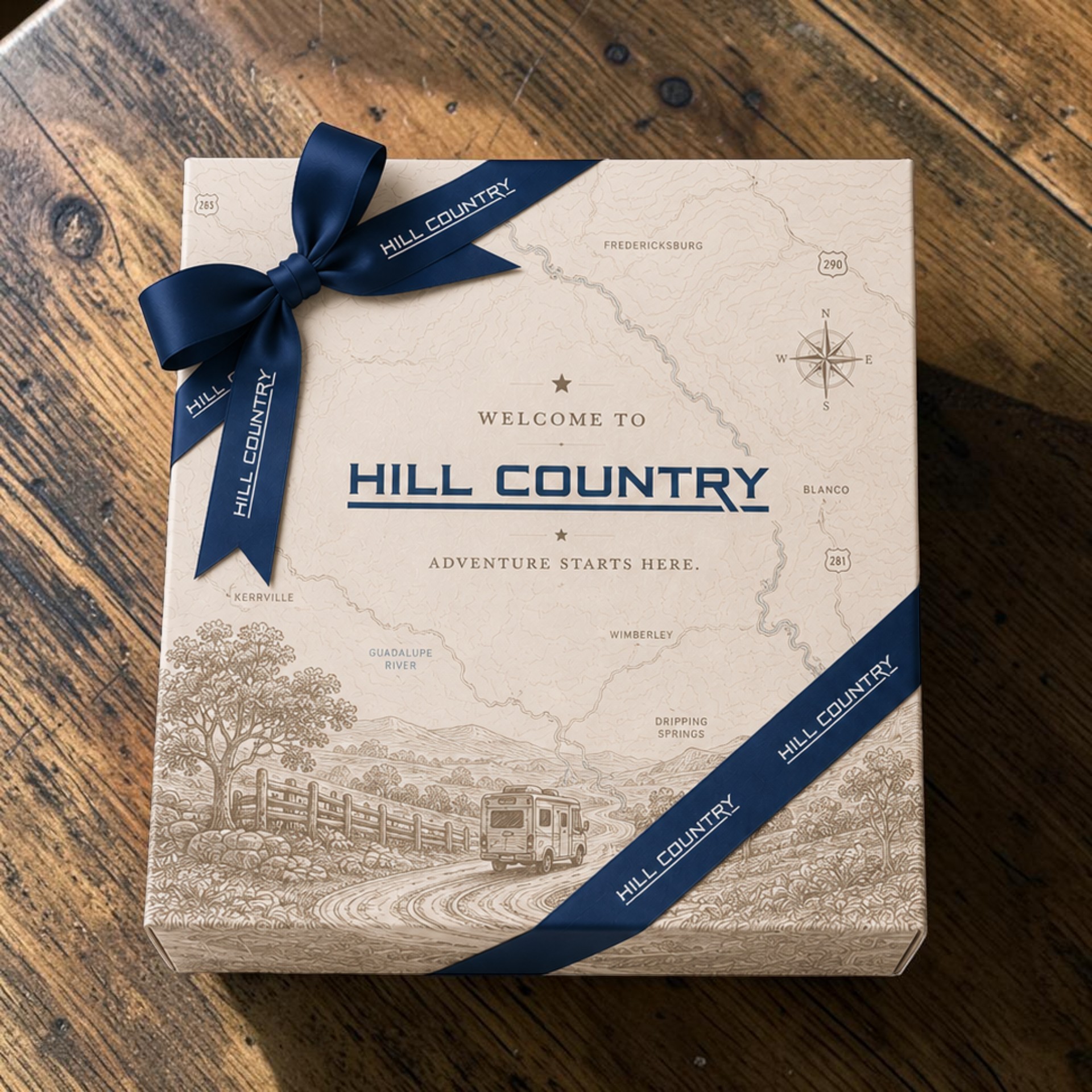 Custom Hill Country gift box with navy branded ribbon and illustrated Texas landscape packaging